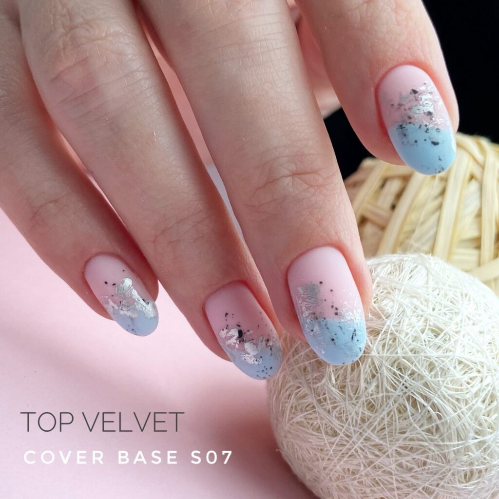 Uñas almendradas en rosa pastel con la punta en azul celeste y motas plateadas