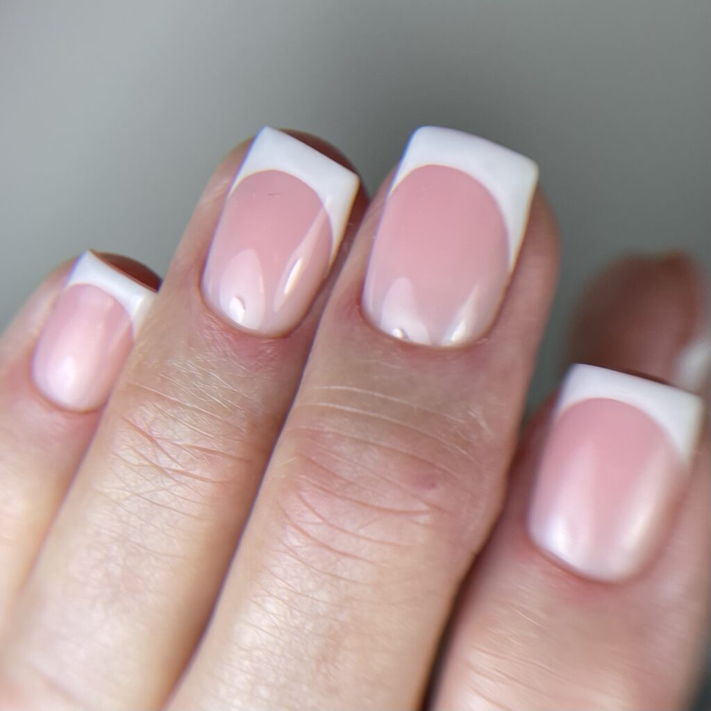 Uñas cortas cuadradas con manicura francesa blanca sobre base rosa