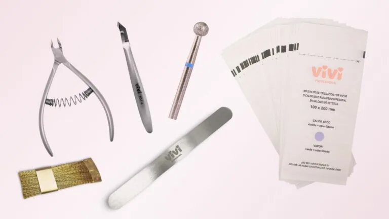 Herramientas de manicura para esterilizar: alicates cortacutículas, fresa de diamante, base metálica de lima, cepillo de latón y bolsas de esterilización